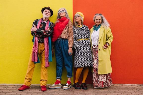 Four seniors in bright patterned outfits standing together posing