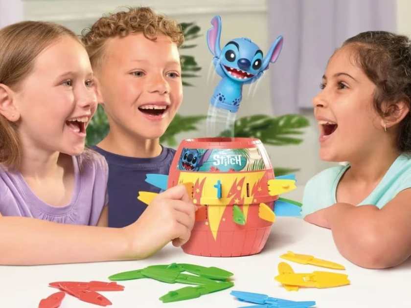 Kids playing the Lilo and Stitch pop up game looking excited as Stitch pops out of the tube